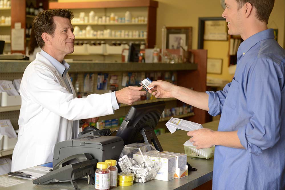man hand co-op connections card to pharmacist
