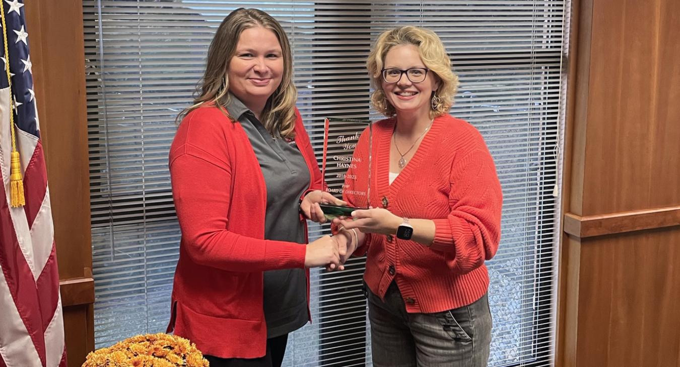 Chrissy Haynes (left) accepts her plaque from Nicole Arnold.